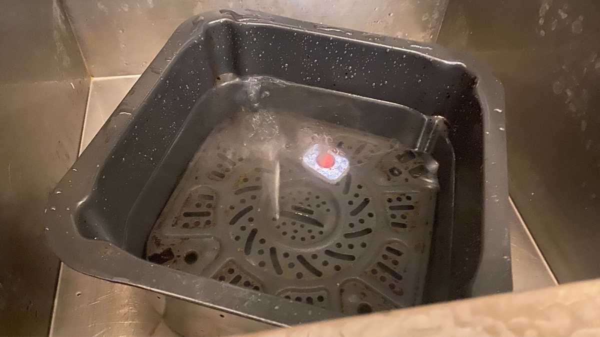 A dishwasher tablet in an air fryer basket