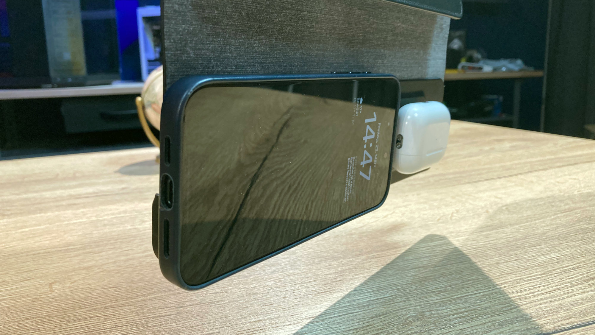 iPhone 15 Pro Max und Airpods Pro hängen magnetisch an der Journey NEXA, die über einem Tisch in der Luft gehalten wird