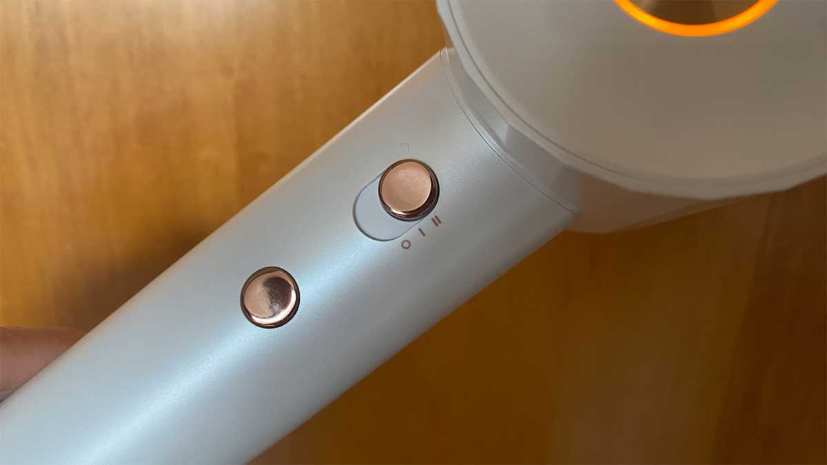 The rose gold control buttons of the hair dryer