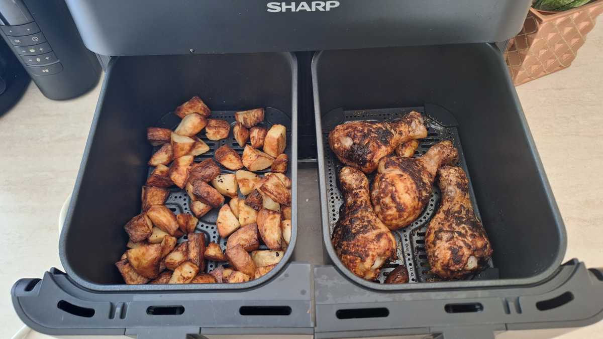 A view of potatoes and chicken thighs cooked in two separate drawers in the Sharp Dual Drawer 8l Digital Air Fryer with Sync Finish