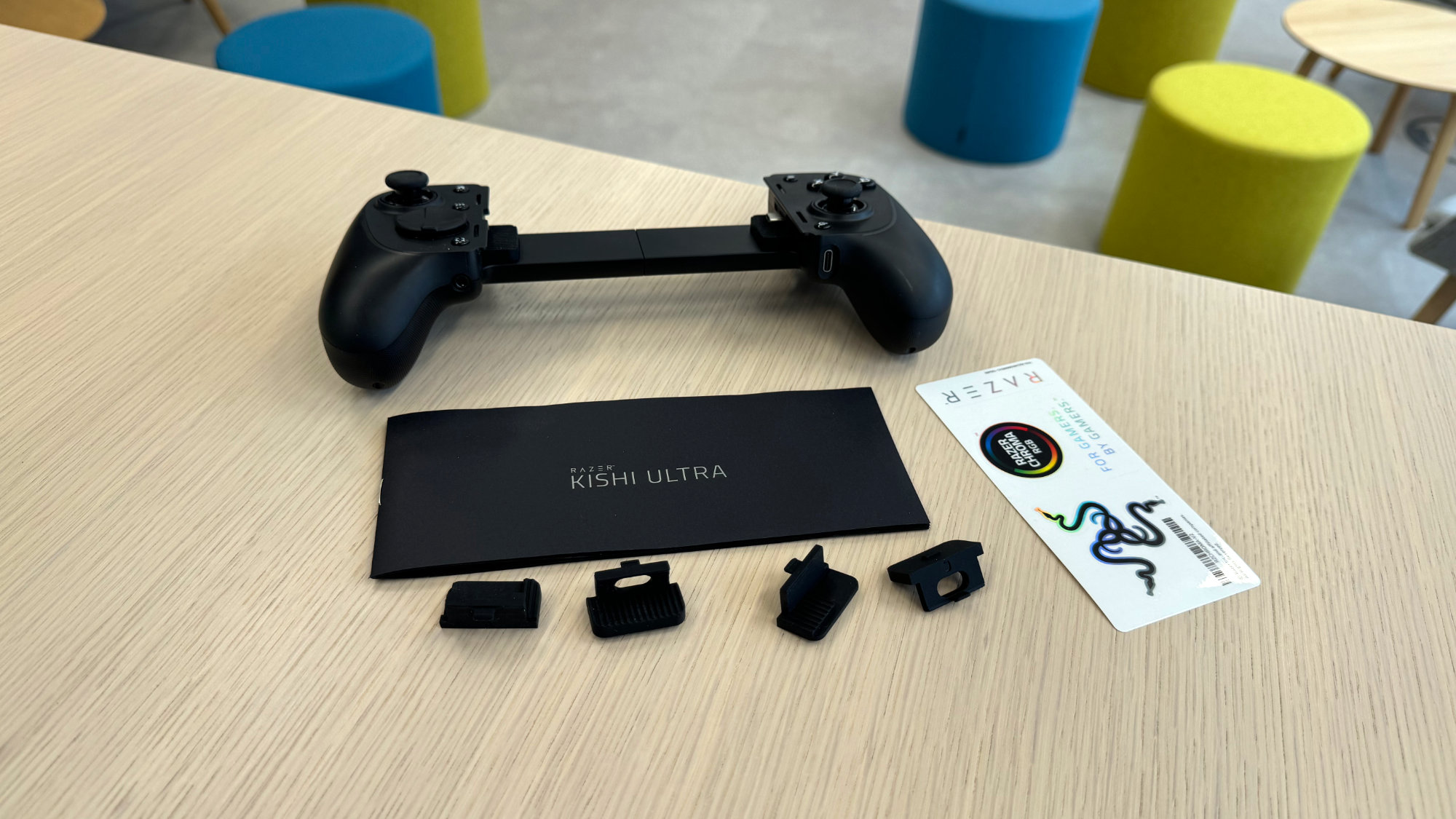 Lieferumfang des Razer Kishi Ultra, einschließlich Controller, zwei Paar Gummiadapter, Sticker und Handbuch