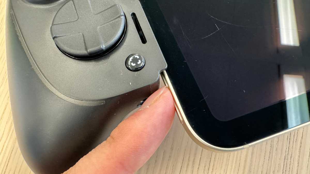 Nahaufnahme des Razer Kishi Ultra mit iPad Mini 6, ein Finger berührt die innere Lautstärketaste nur mit dem Fingernagel