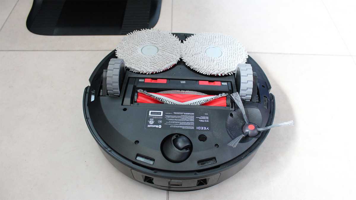The robot vacuum turned upside down to show wheels and mop pads