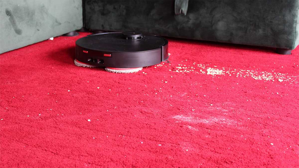 Yeedi vacuums a carpet, showing the oats and flour it missed