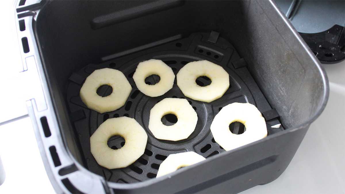 Apple slices dehydrating in an air fryer