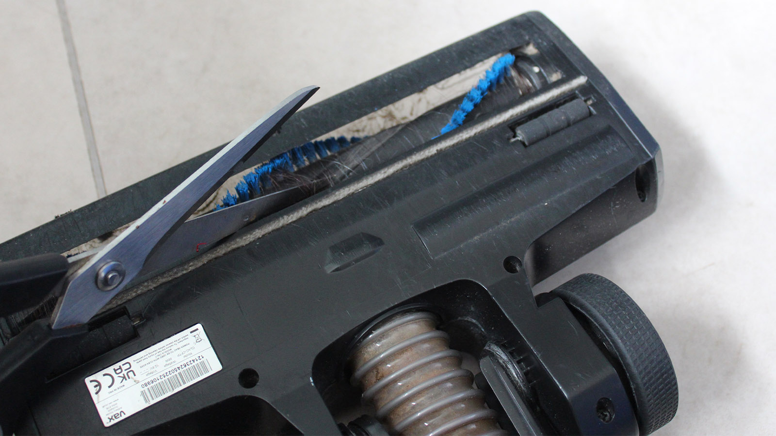 Tijeras cortando el pelo envuelto alrededor del cepillo