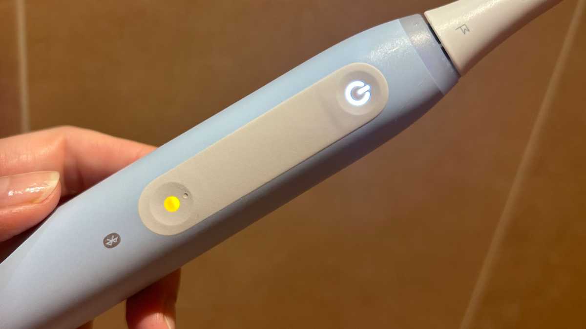 A close-up of the yellow mode button