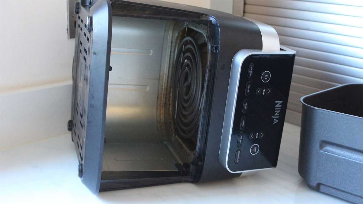 An air fryer turned on its side for cleaning