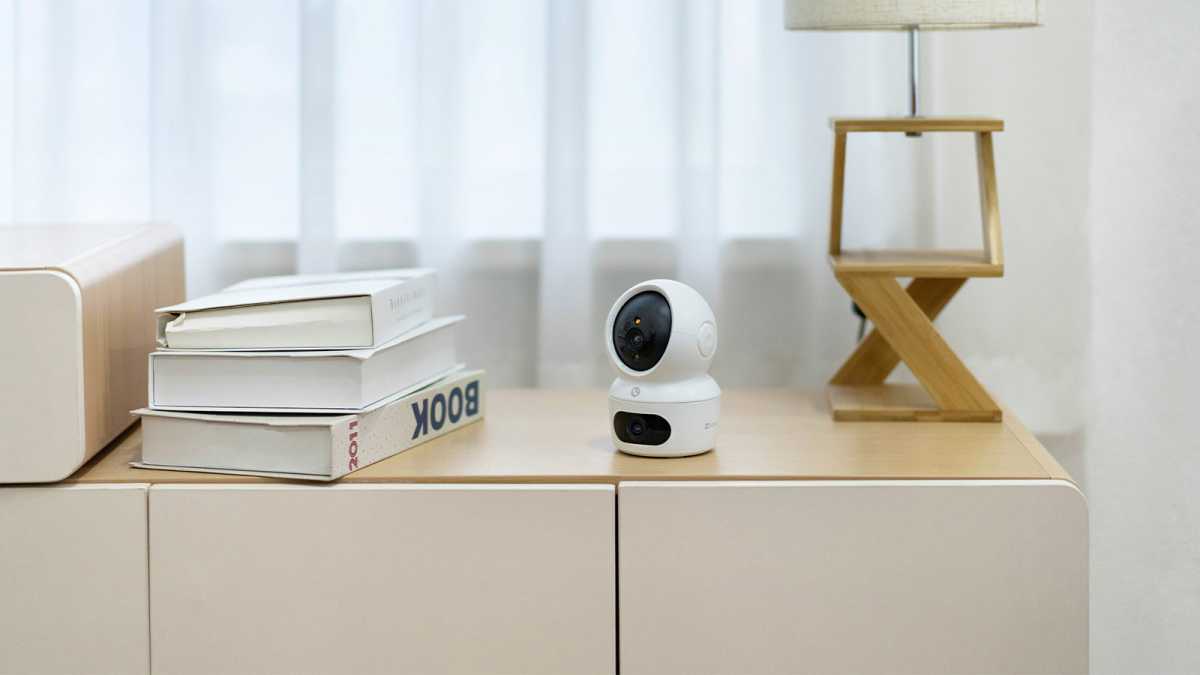 EZVIZ H7c dual-lens indoor camera on a sideboard, next to some books