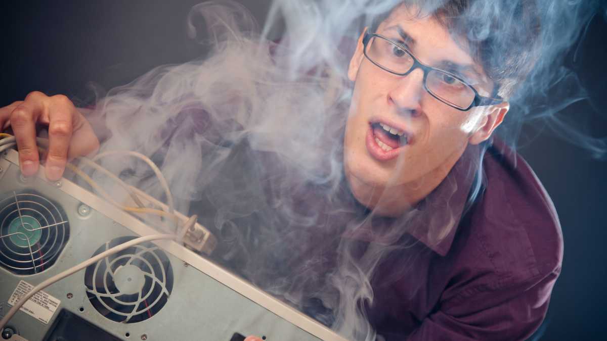 Rauchender PC mit entsetztem Nerd