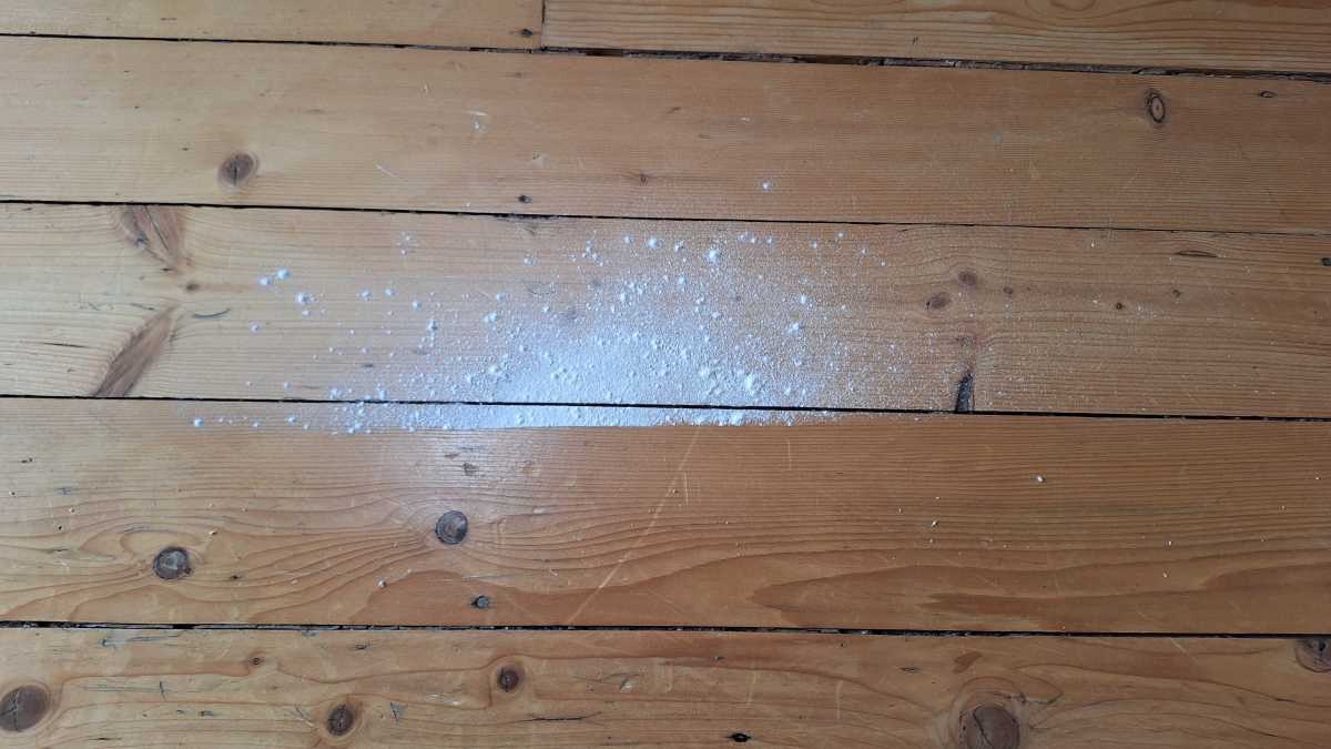 A hardwood floor showing the Tineco iFloor 5 Floor Washer flour test midway.  