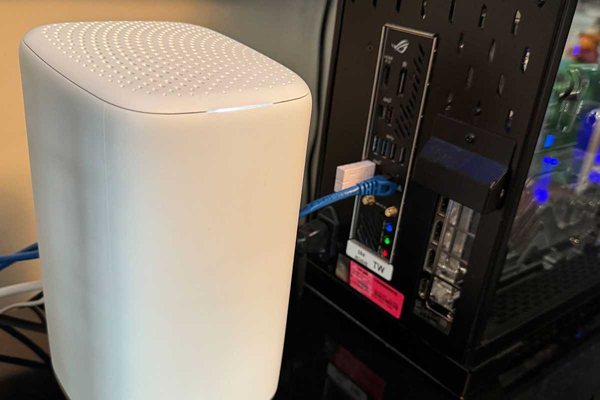 White wireless router next to a desktop PC with Ethernet cable plugged in