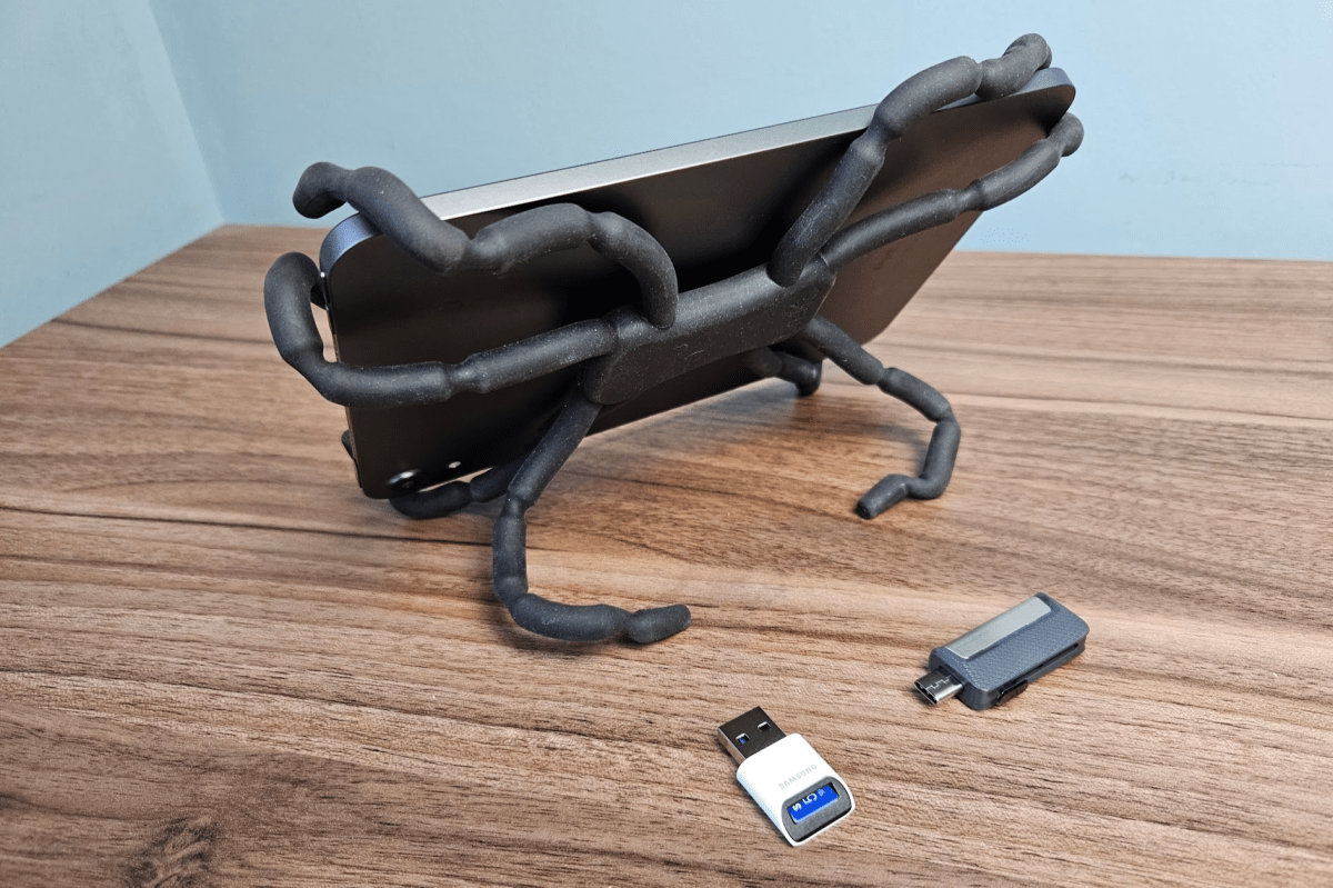 Un soporte estilo araña que sostiene un iPad Mini, con una memoria USB MicroSD y una unidad flash USB doble