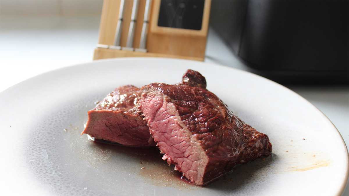 Steak on a plate, with the Meater probe behind it