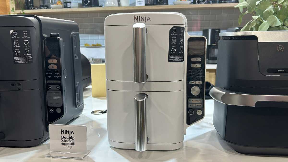 Double stack of white ninjas on a counter, between two other air fryers