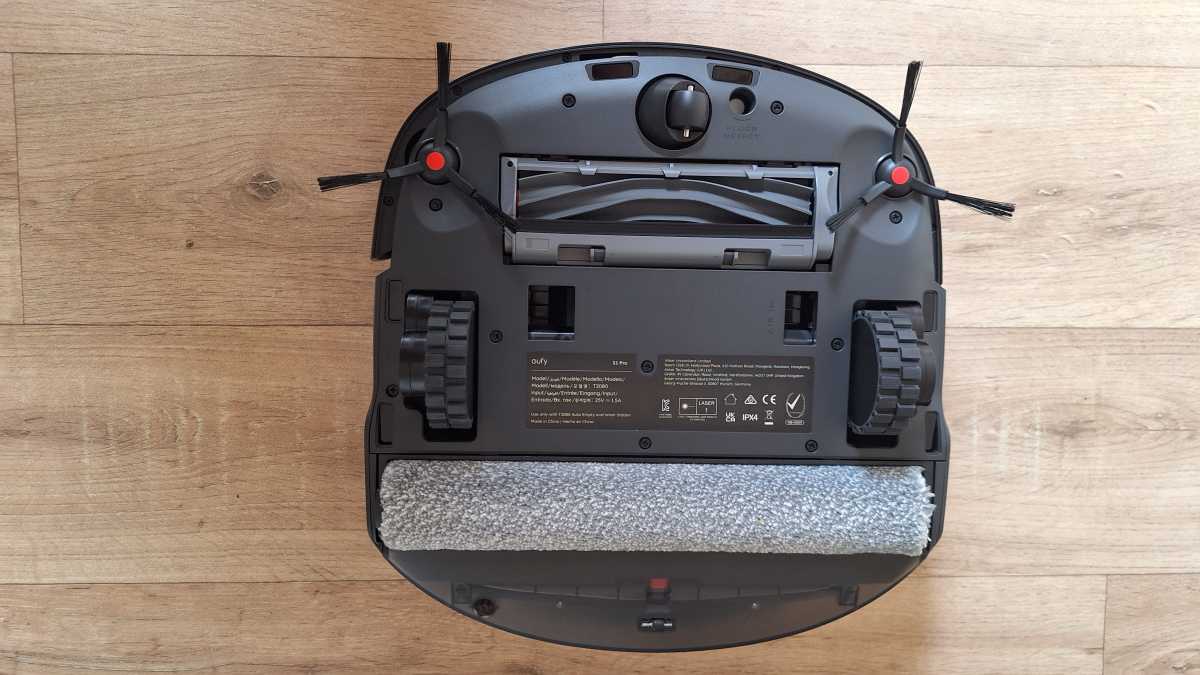 A top view of the eufy S1 Pro robot vacuum and mop underside, showing wheels, roller, brush and side brushes.