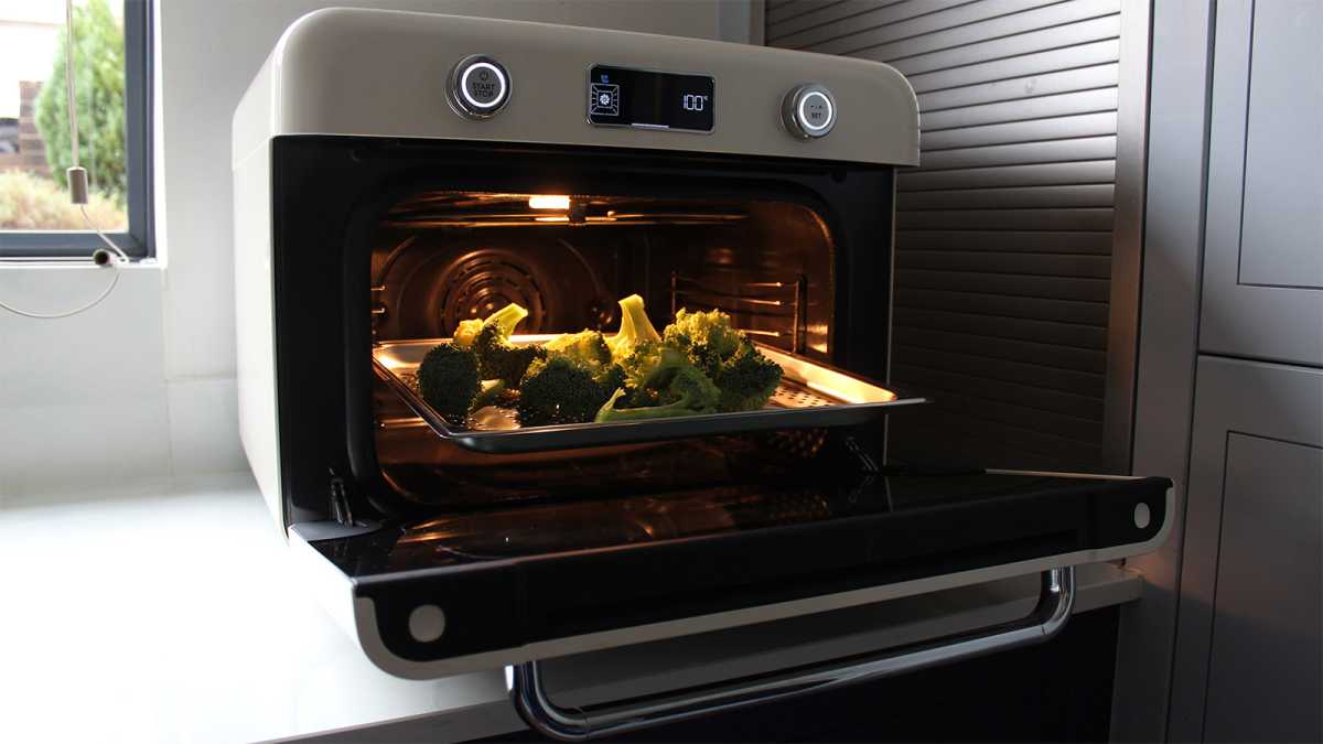 The oven open, with broccoli inside, waiting to be steamed