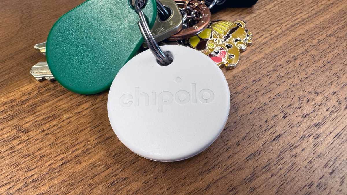 Chipolo One Point på en nyckelknippa liggandes på ett bord.
