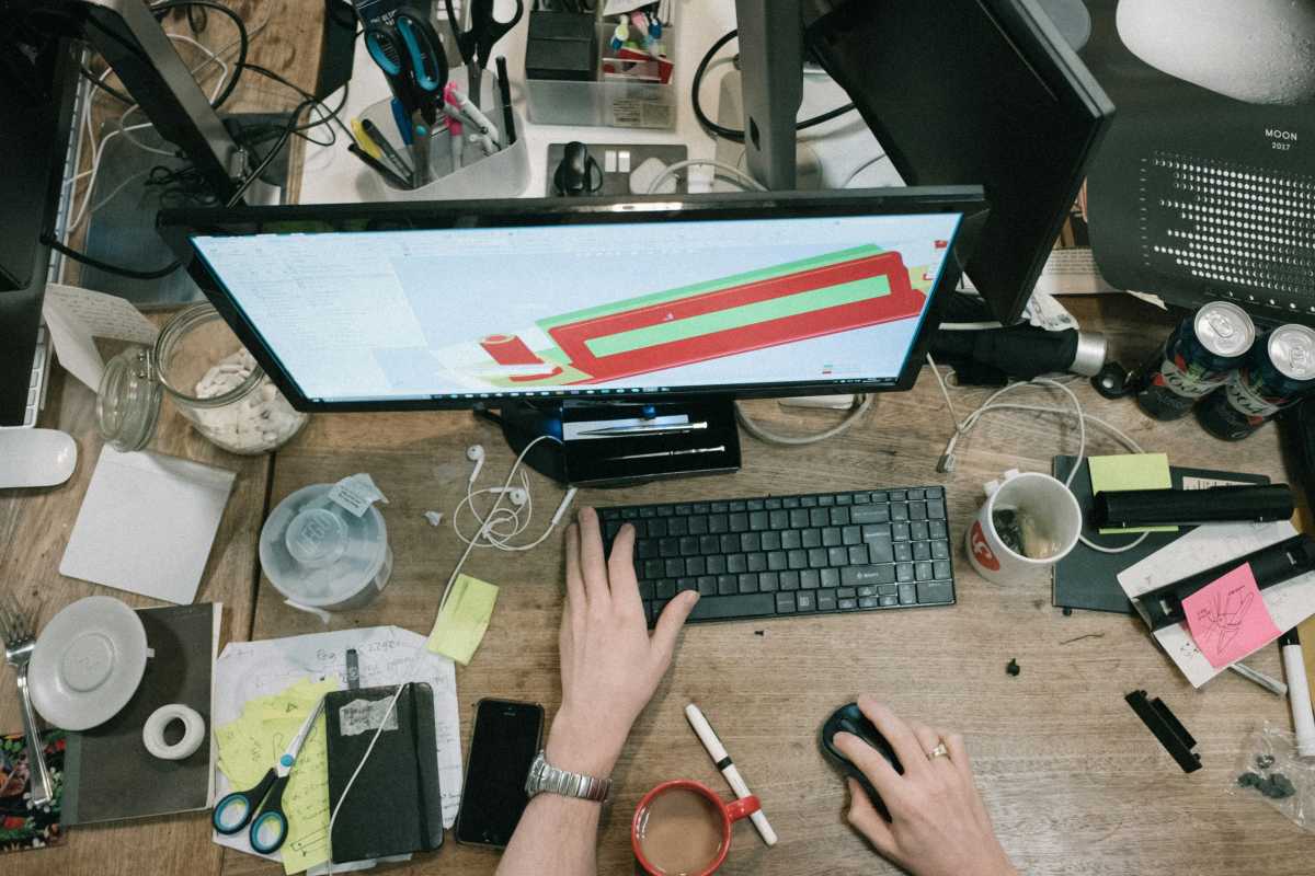 Keyboard and mouse cramped on an extremely messy cluttered workspace