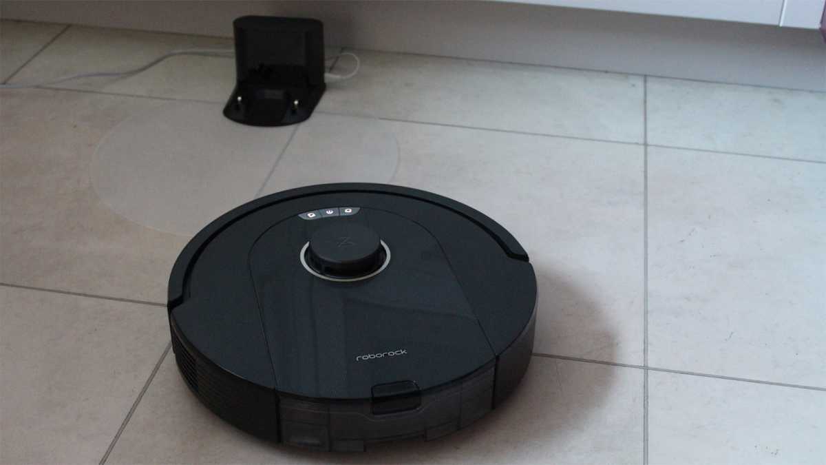 The Q5 Pro on a tiled floor, with its charging base in the background