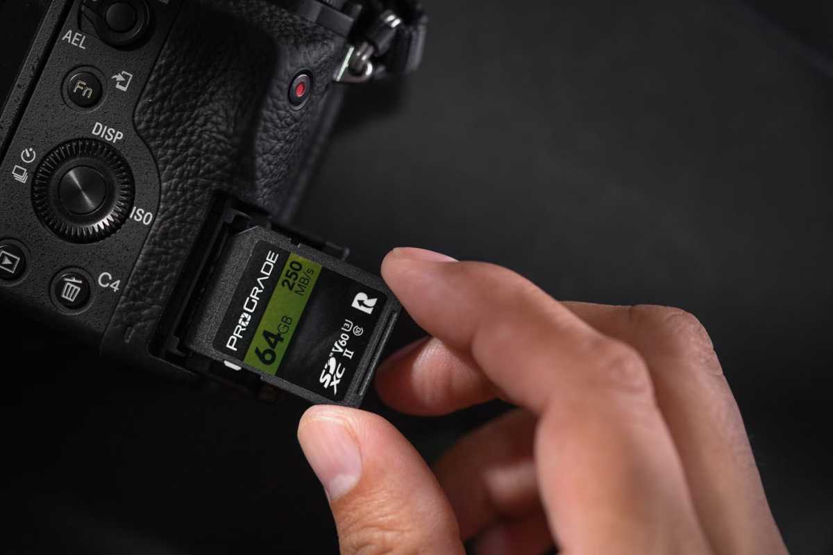 Man putting ProGrade 64GB SD card into DSLR camera