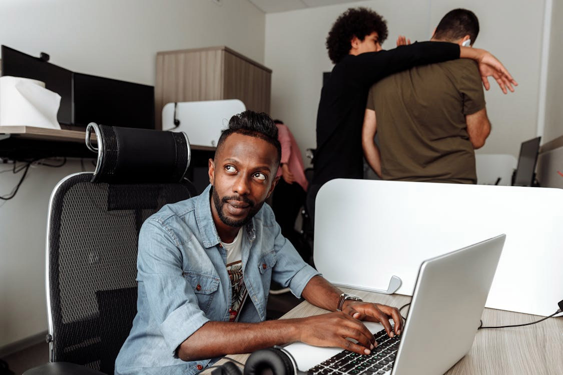 man using laptop in small cubicle