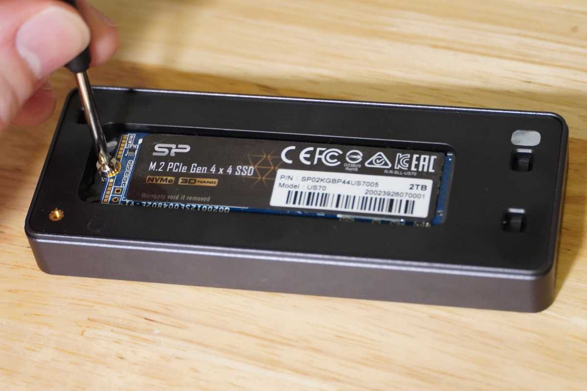 Silicon Power NVMe SSD being screwed into an enclosure