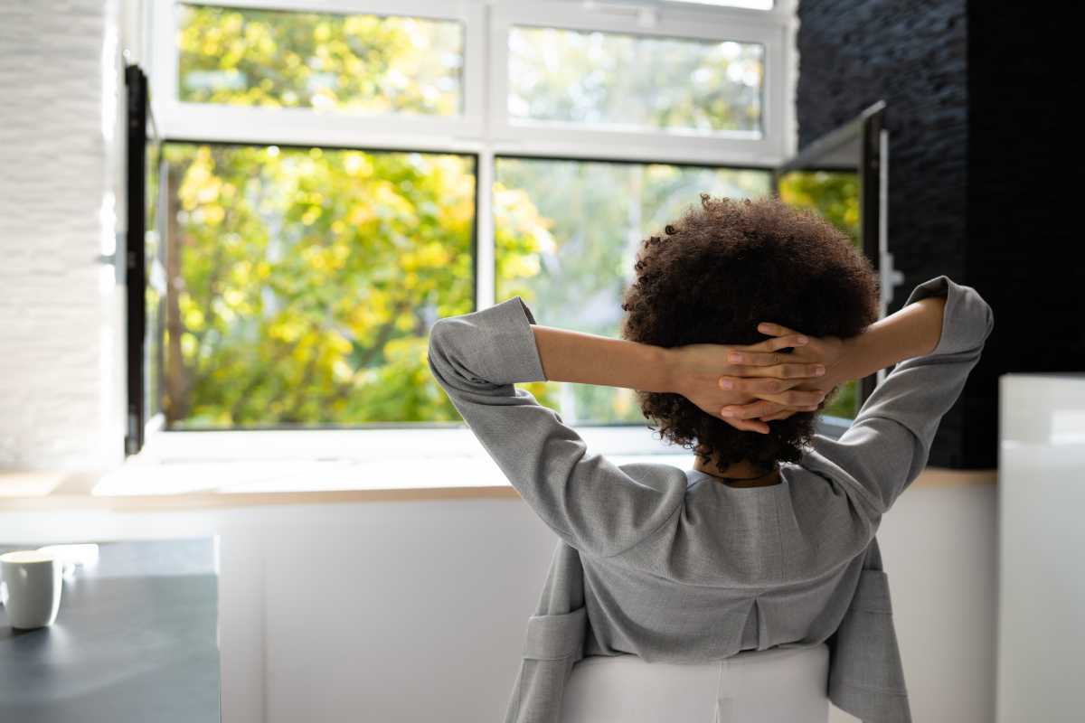 Woman in home office enjoying fresh air with the windows open