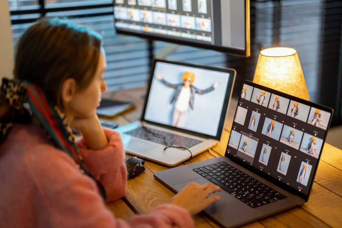 Woman working at home in office with two MacBook laptops