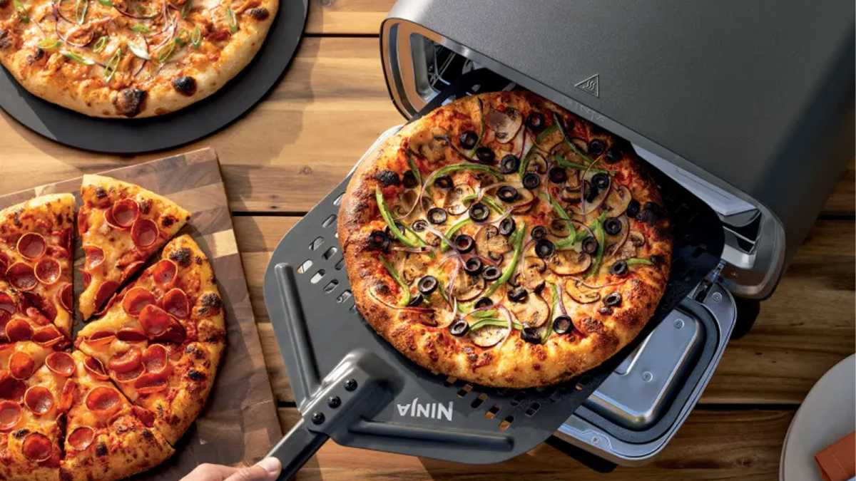 Overhead view of pizza that is removed from the oven, with other pizzas on the table