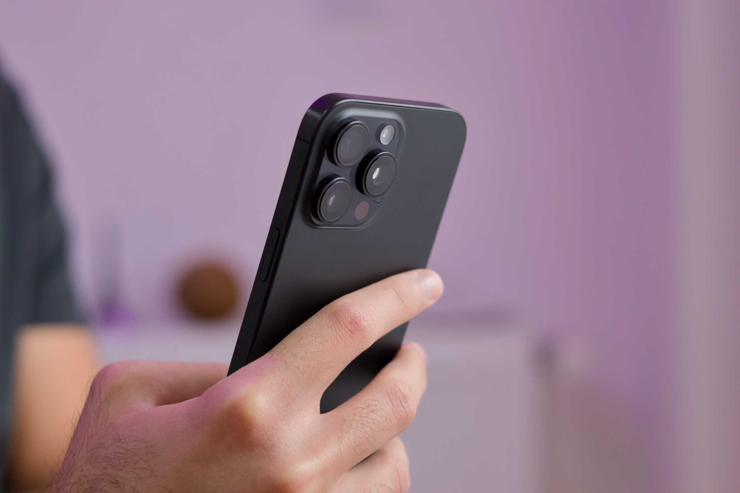 person holding an iPhone 16 pro showing the rear camera