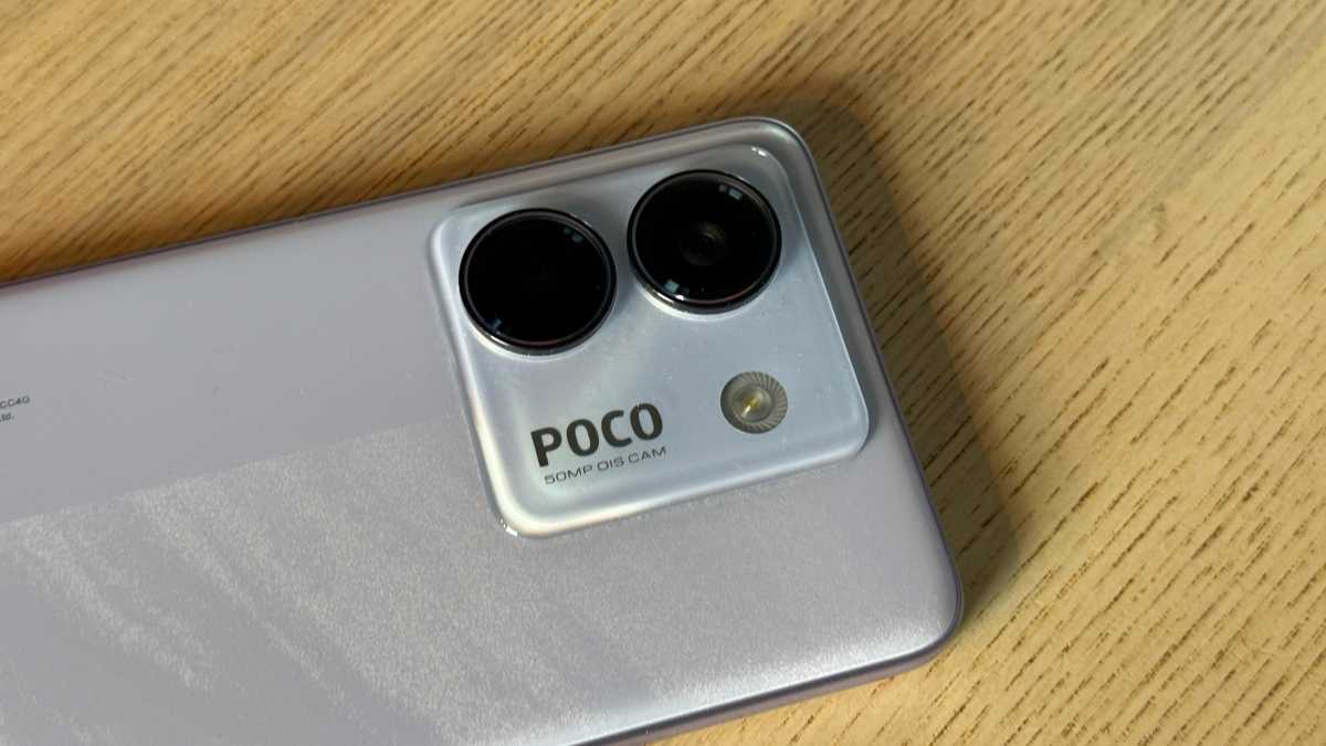 A photo of the Poco M7 Pro against a neutral backrground on a wooden table.