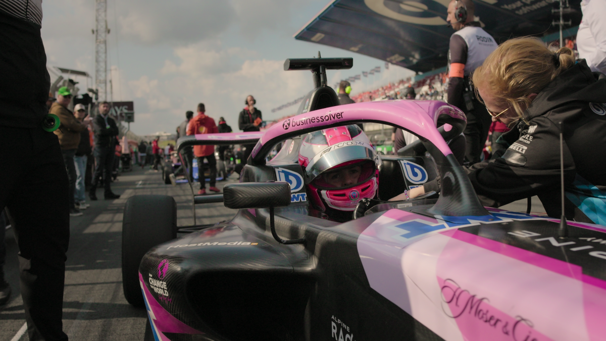 A photo of Abbi Pulling in her race car with a helmet on