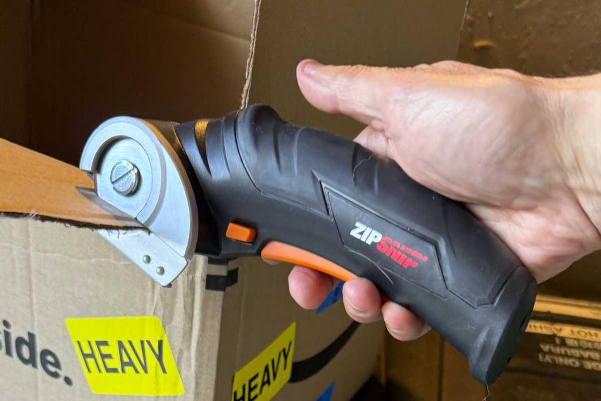 Man's hand holding the Worx electric scissors