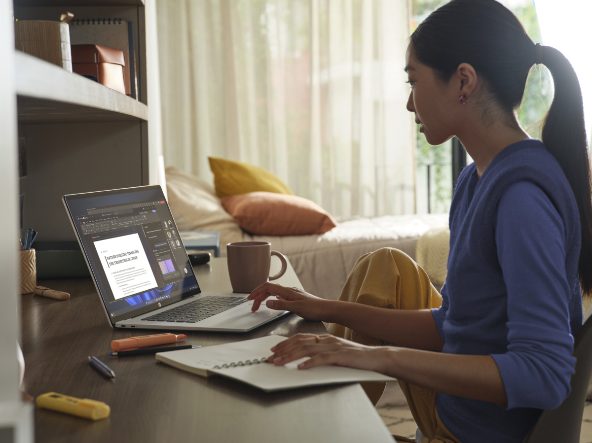 HP Omnibook 5 16: woman using laptop on desk with notebook
