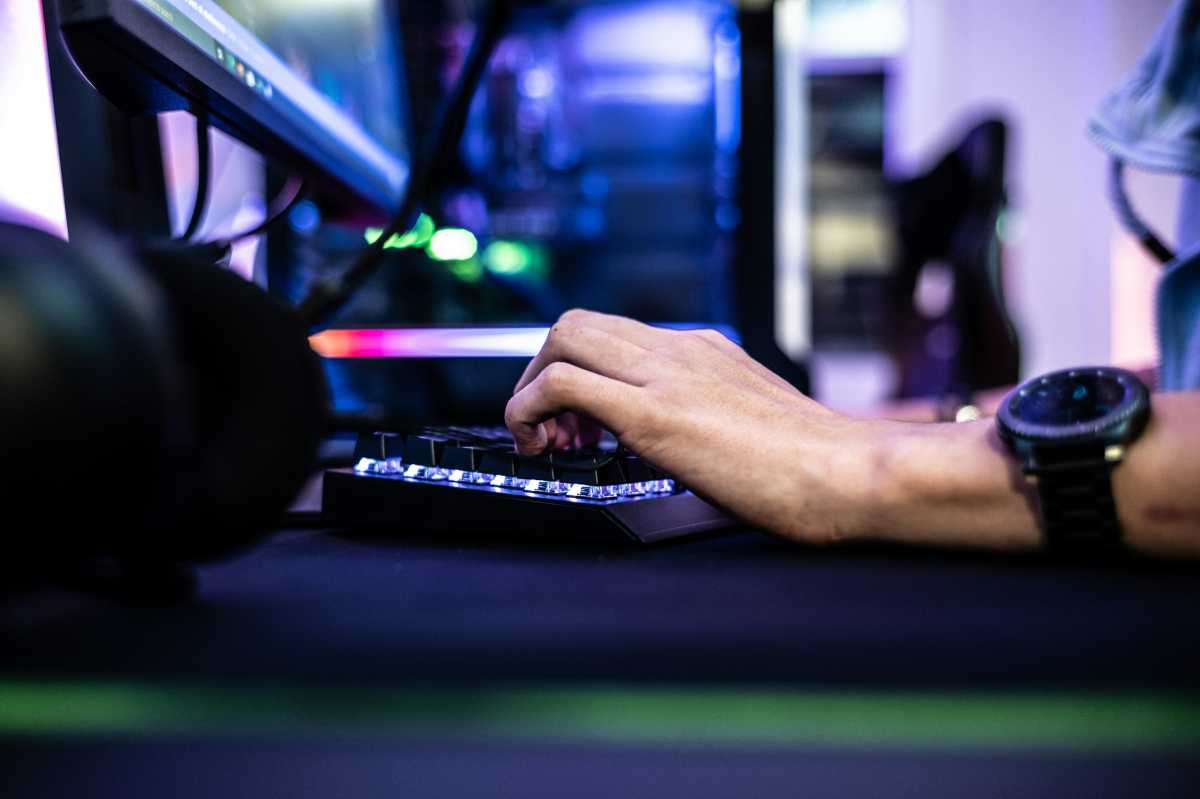 Gamer left hand on keyboard while playing on gaming PC