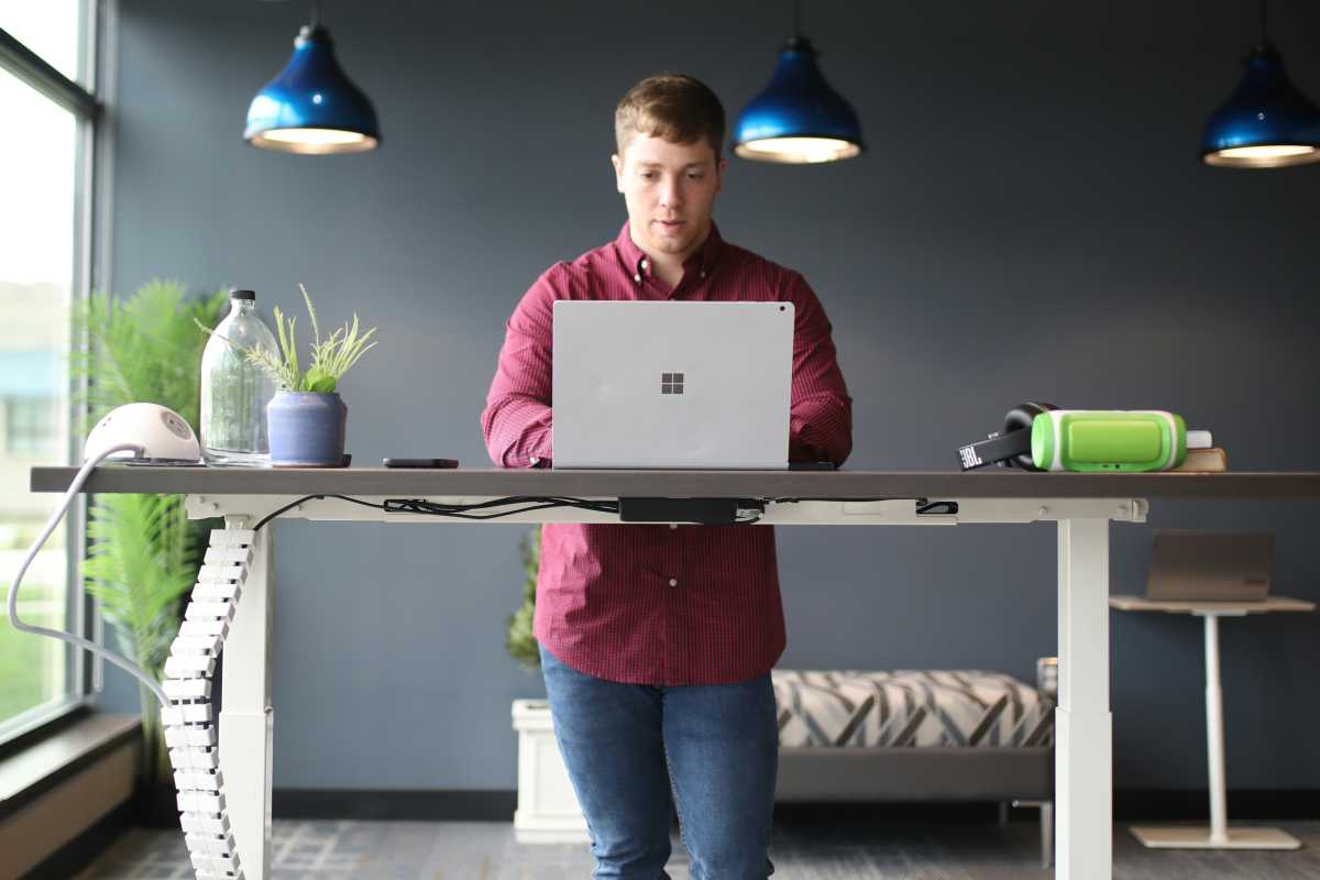 Man at standing desk working on Windows laptop
