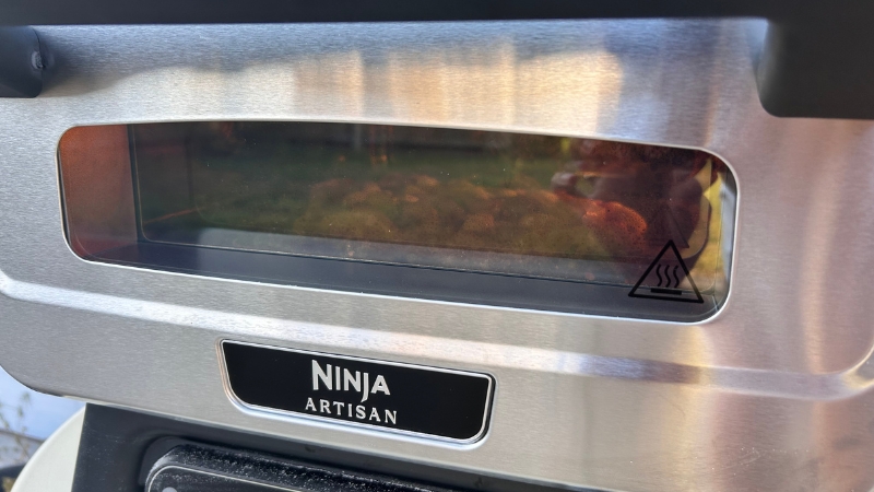 Cooking pizza seen through the Artisan window