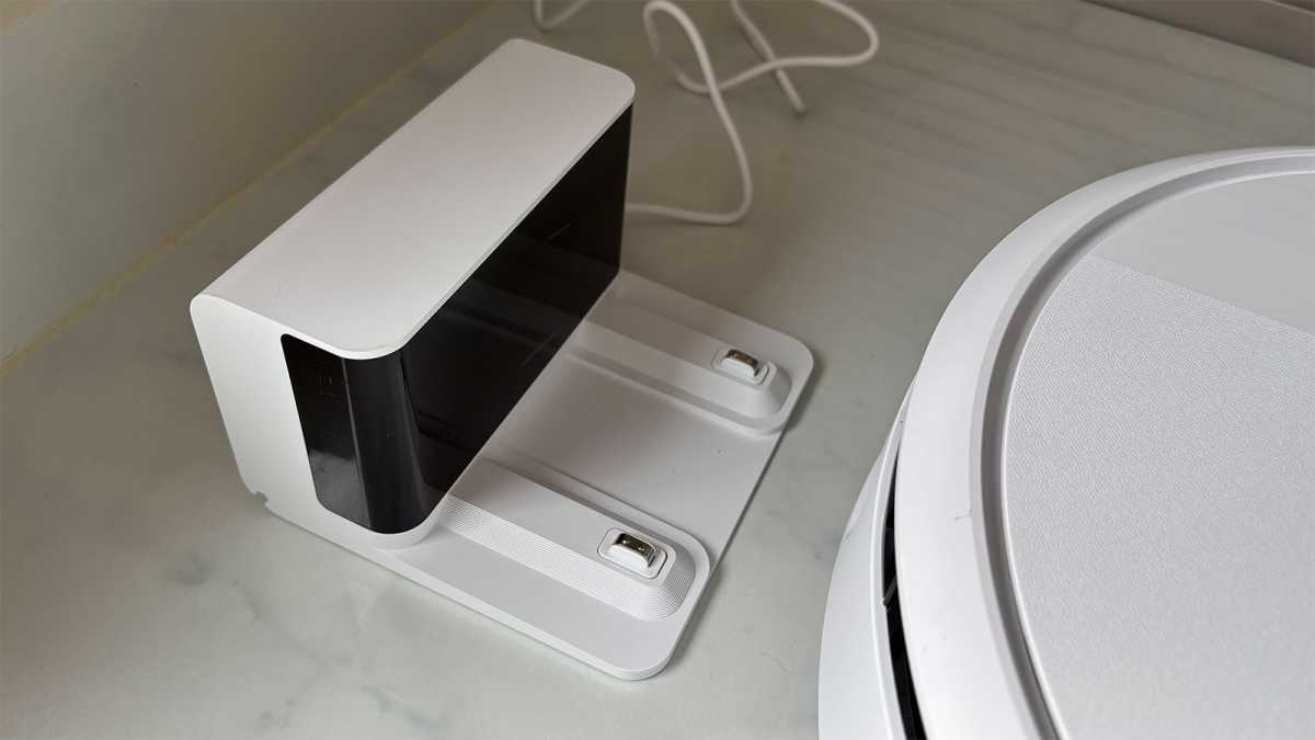 The small dock next to the edge of the robot vacuum
