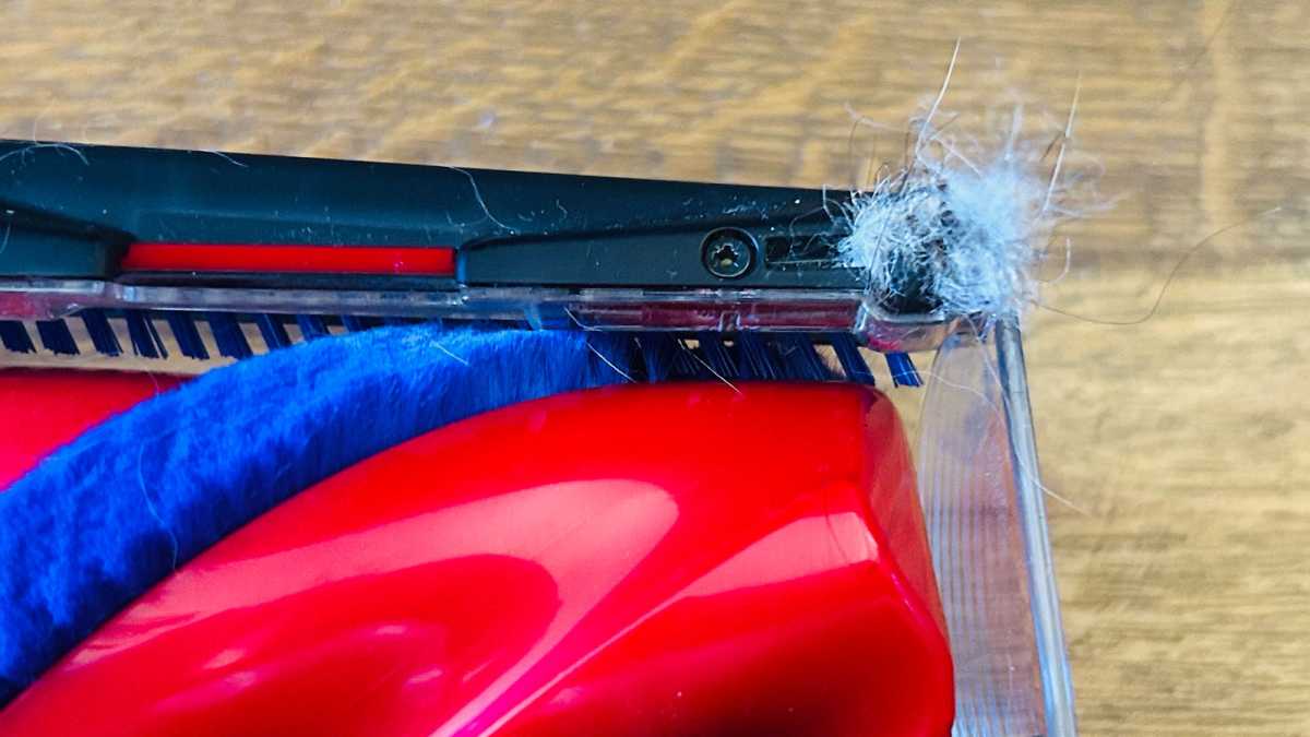 A close-up of one of the wheels, which is hidden behind a tangle of pet fur