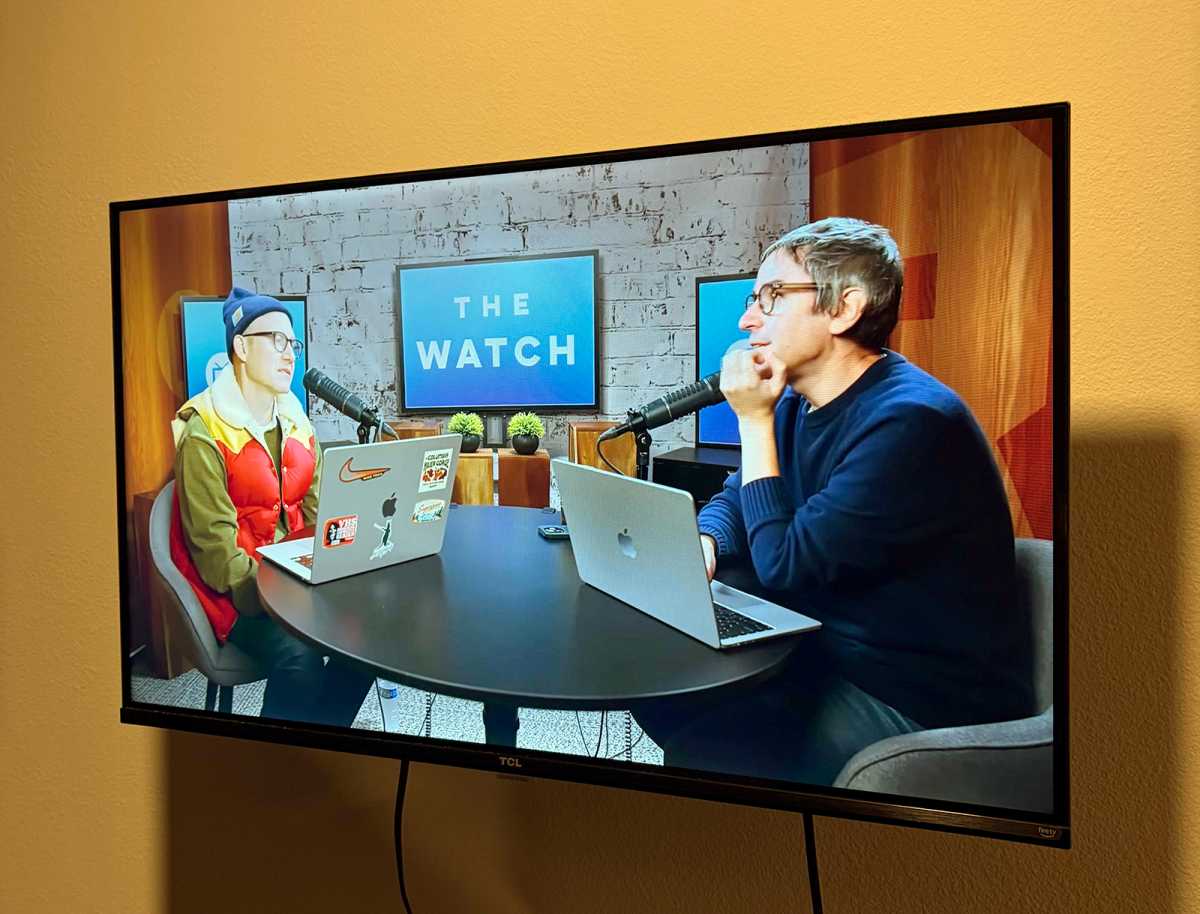 TCL 32 Inch TV, mounted on the wall, and playing The Watch podcast on YouTube