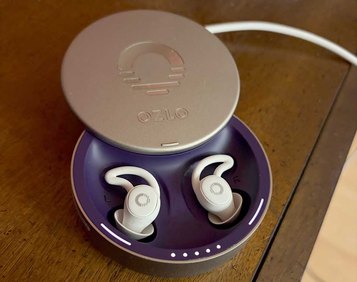The Ozlo Sleepbuds, in their case, on a wooden desk.