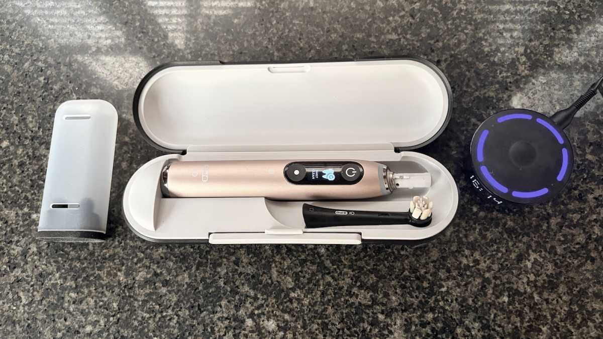 The brush in the travel case, with brush head holder and charger 