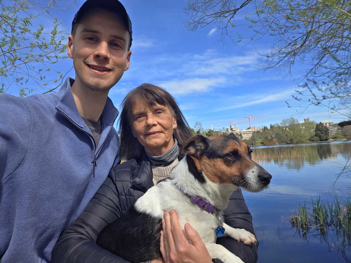 A man, woman and dog with a lake in the background