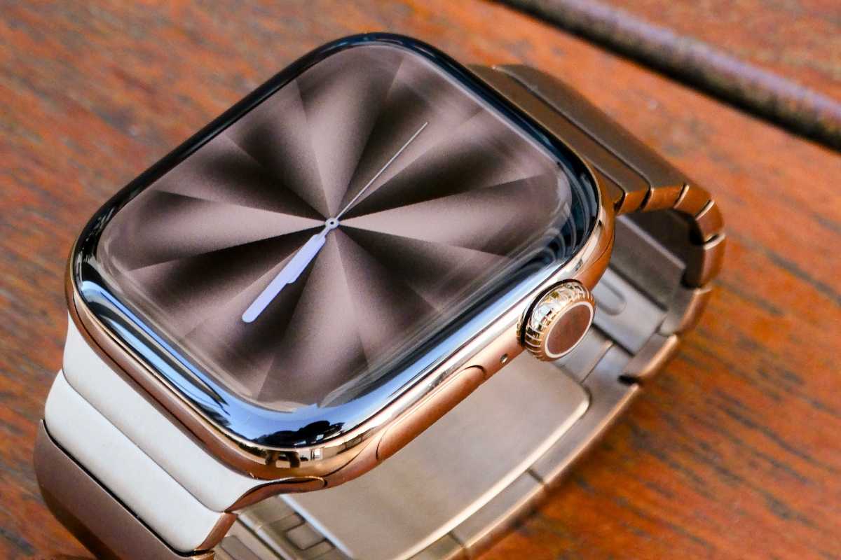 Apple Watch in gold aluminum on a table with Pride Luminance watch face showing