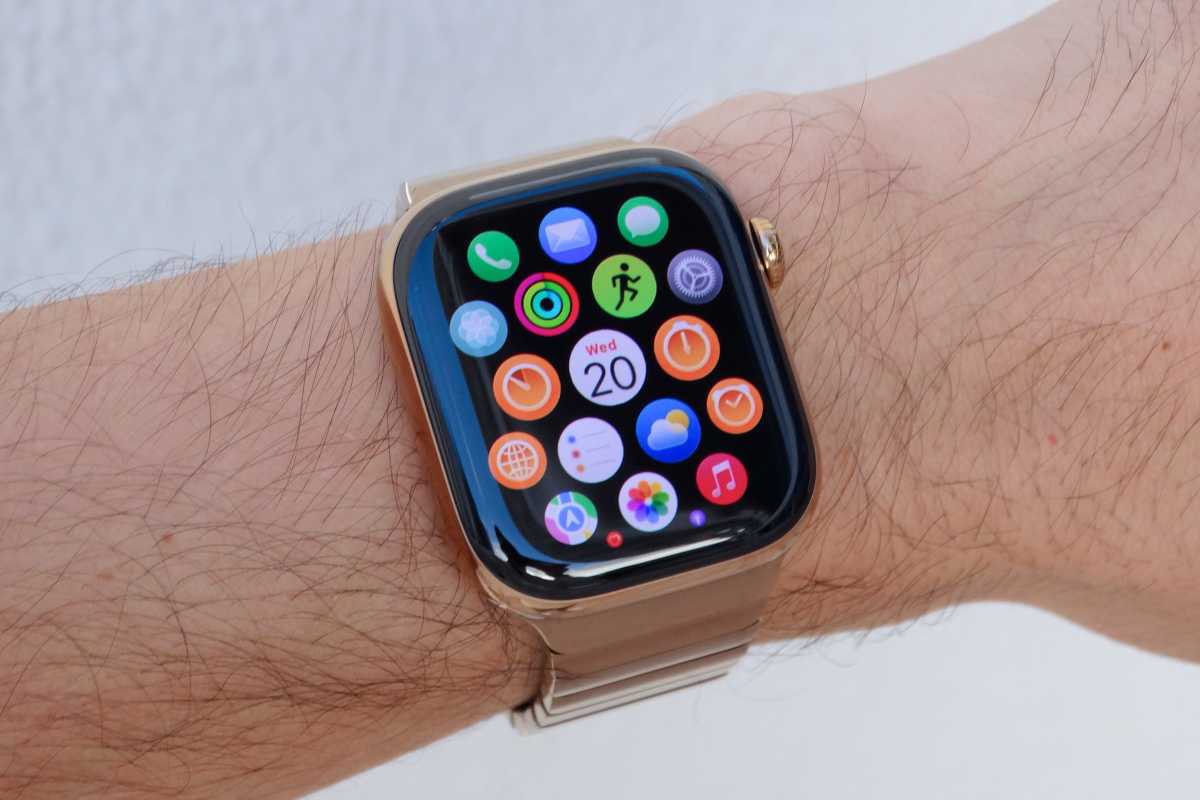 Apple Watch in gold aluminum on a wrist with app grid showing