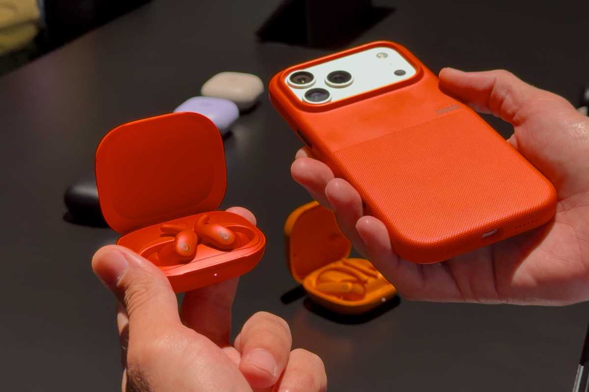 Powerbeats Fit inside a case next to the iPhone 17 Pro Max in Cosmic Orange