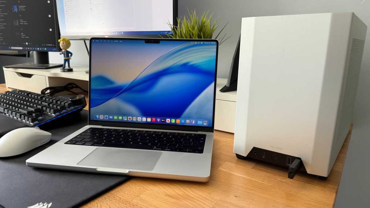 MacBook Pro next to a PC tower on a desk