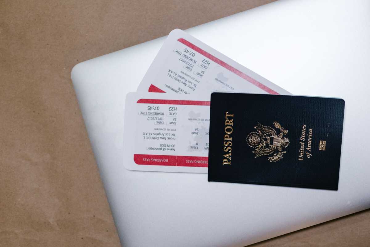 Passport and boarding passes on top of a laptop