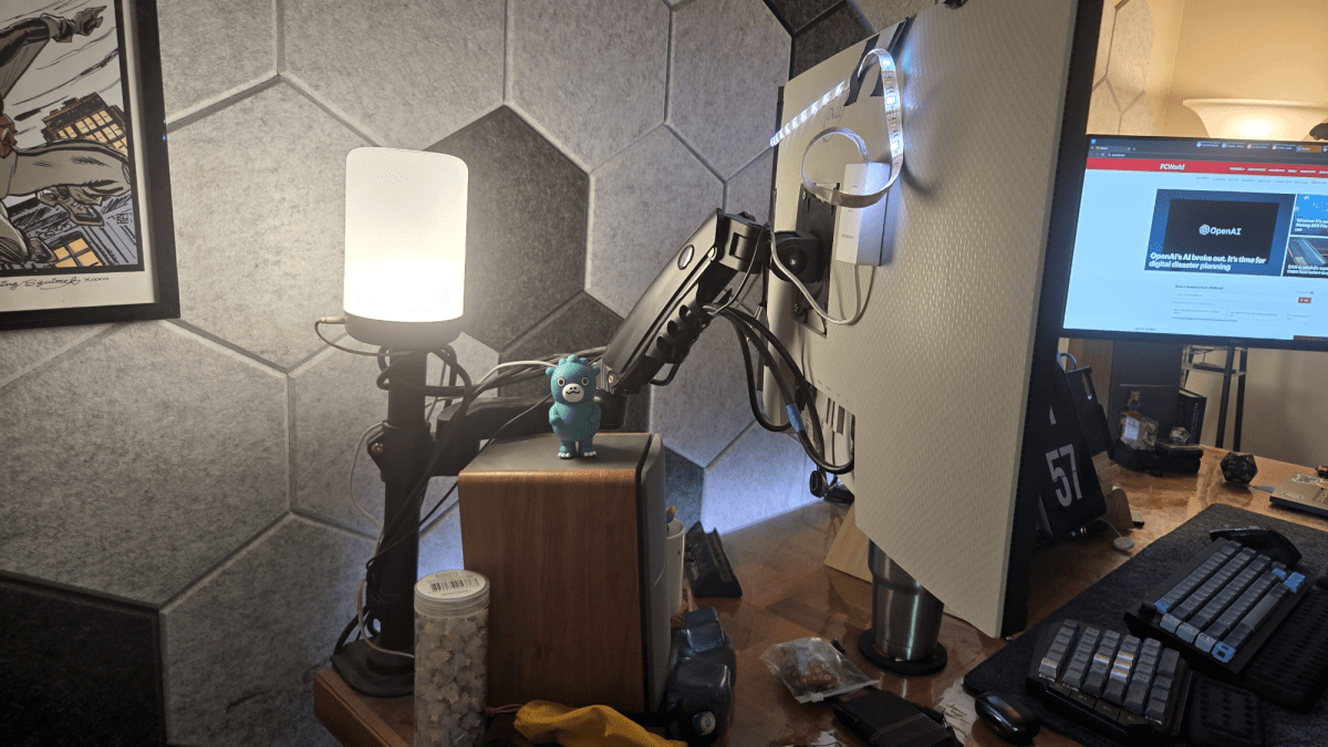 monitor on a stand with a speaker and a tiny Godzilla
